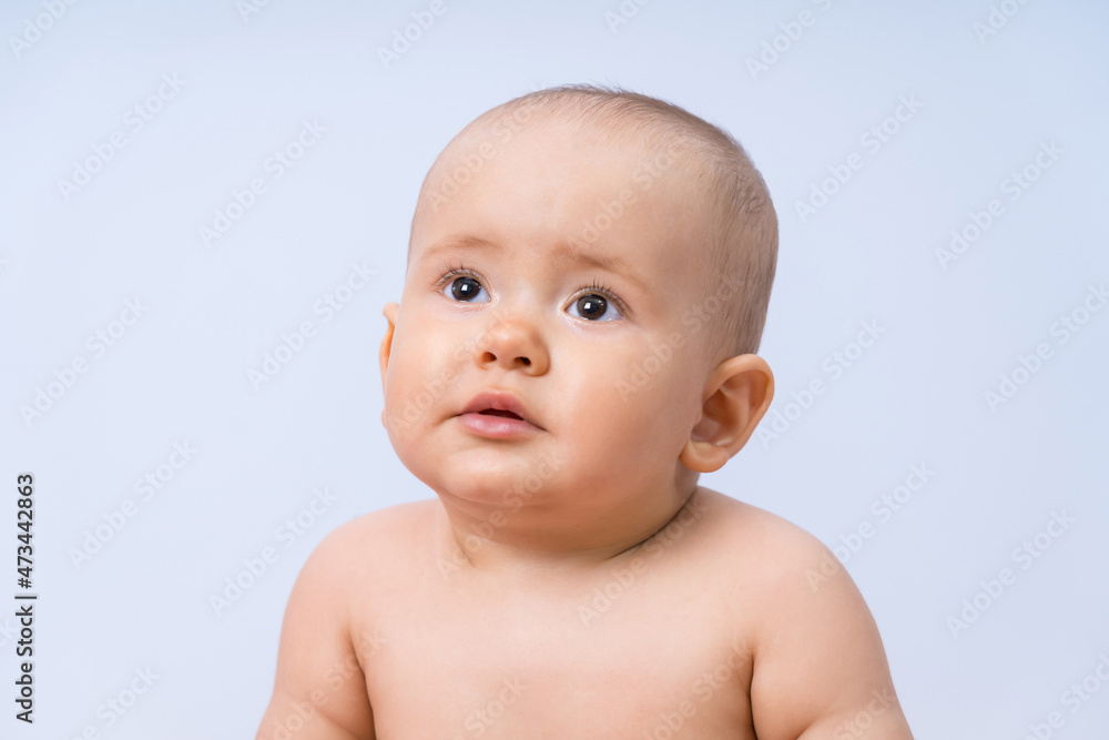 Portrait of a newborn baby 7-10 months looking upwards.