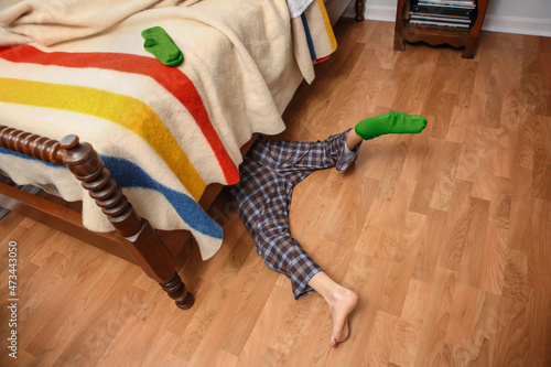 Young boy searching for his lost sock under the bed photo