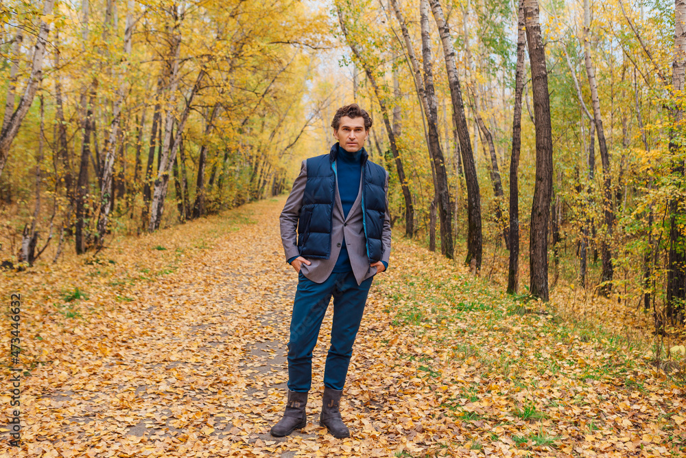 Tall handsome man walking in the autumn alley Tall handsome man walking in the autumn alley