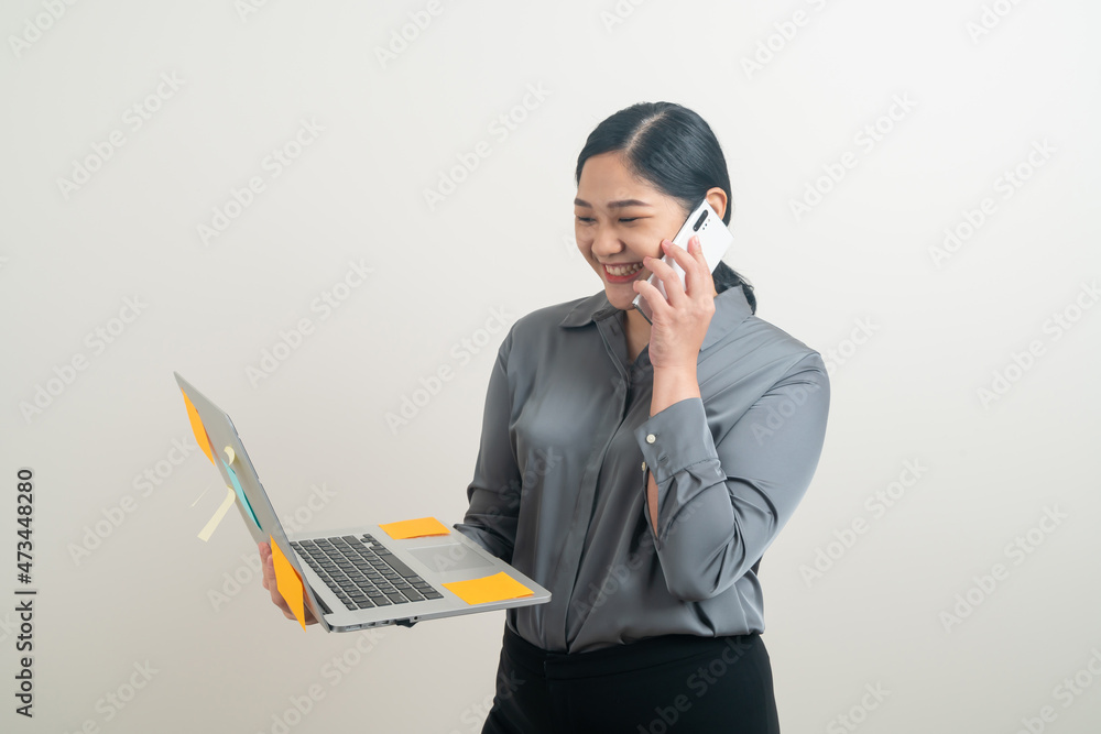Asian business woman talking telephone with hand holding laptop Asian business woman talking telephone with hand holding laptop