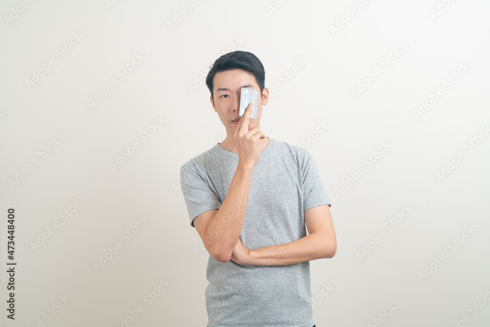 young Asian man holding credit card young Asian man holding credit card