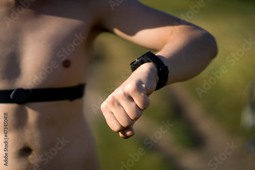 Man puts on a heart rate monitor before jogging.