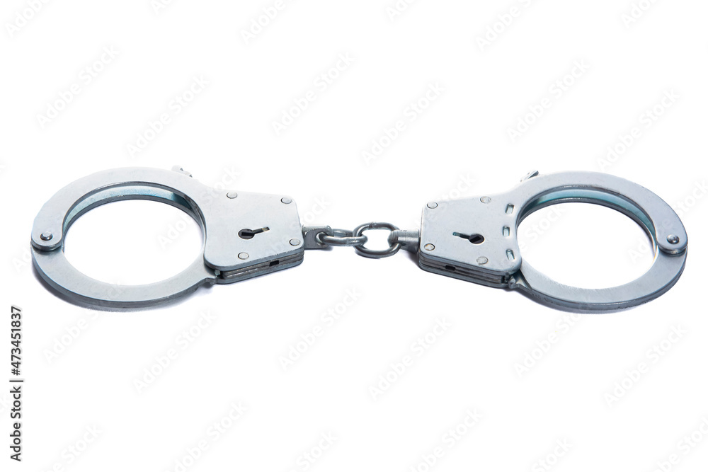 Metal handcuffs on a white isolated background Metal handcuffs on a white isolated background