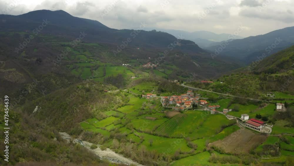 Aerial Beautiful Houses On Hills Green Landscape, Drone Flying Downward Over River - Apennine Mountains, Italy Aerial Beautiful Houses On Hills Green Landscape, Drone Flying Downward Over River - Apennine Mountains, Italy