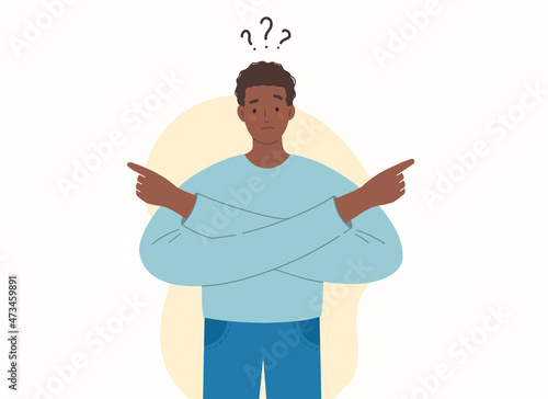 Young African-American makes choice by pointing his hands to the right and to the left. Making decision. Difficult choice between several options.