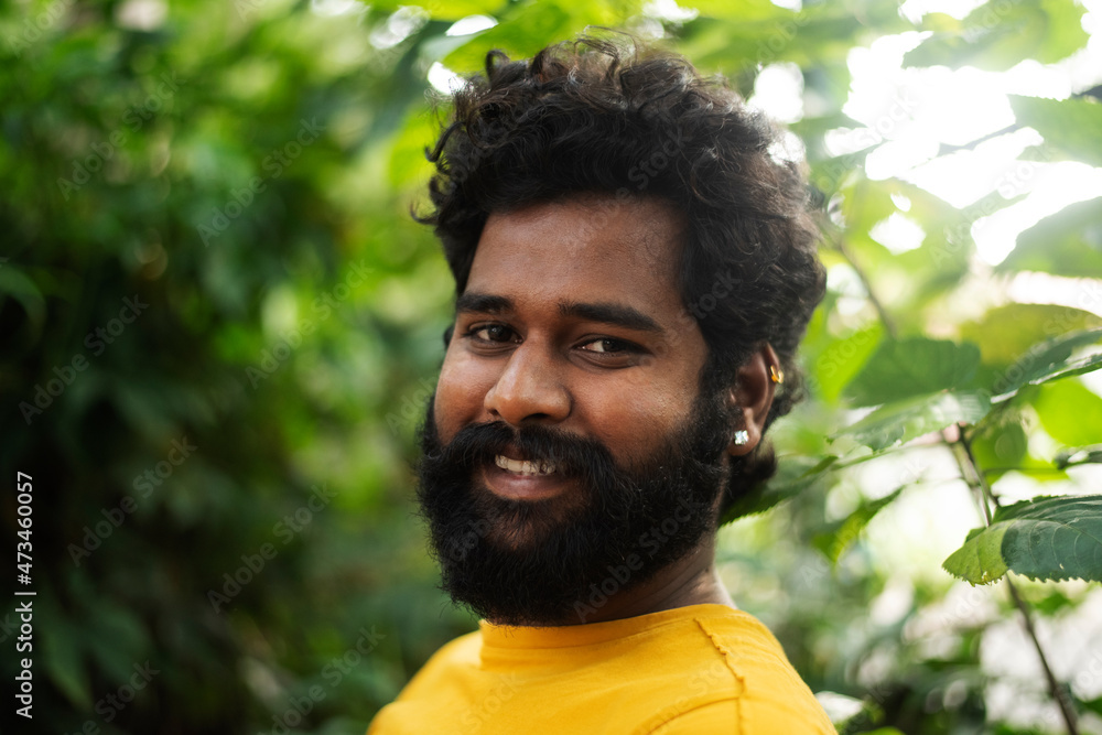 Handsome male model in a public park, Indian male model with green background Handsome male model in a public park, Indian male model with green background