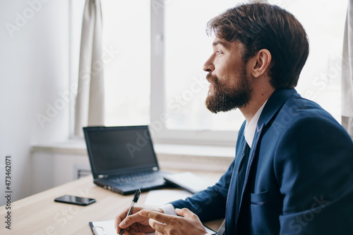 Man sitting at a desk in front of a laptop finance network technologies