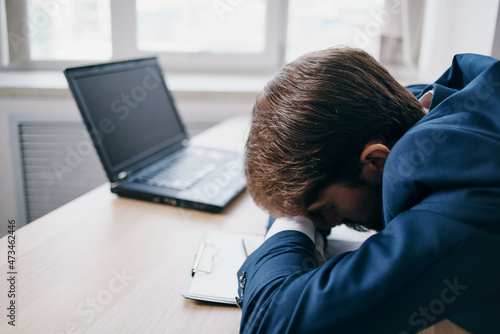 Man sitting at a desk in front of a laptop finance network official