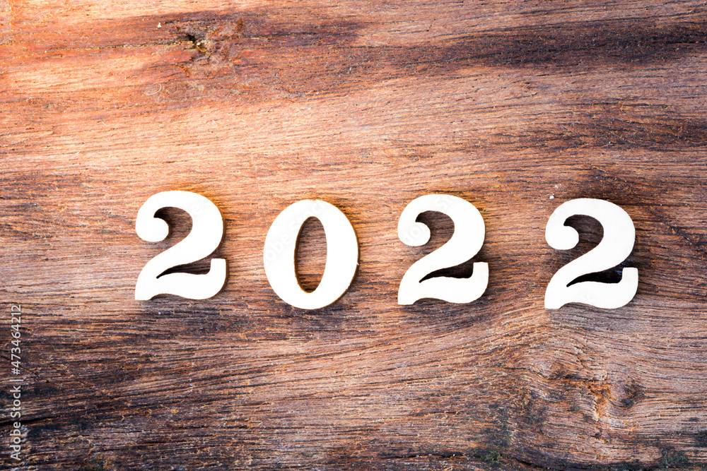 Happy New Year 2022 concept. Wood text on brown nature wood texture pattern. Happy New Year 2022 concept. Wood text on brown nature wood texture pattern.