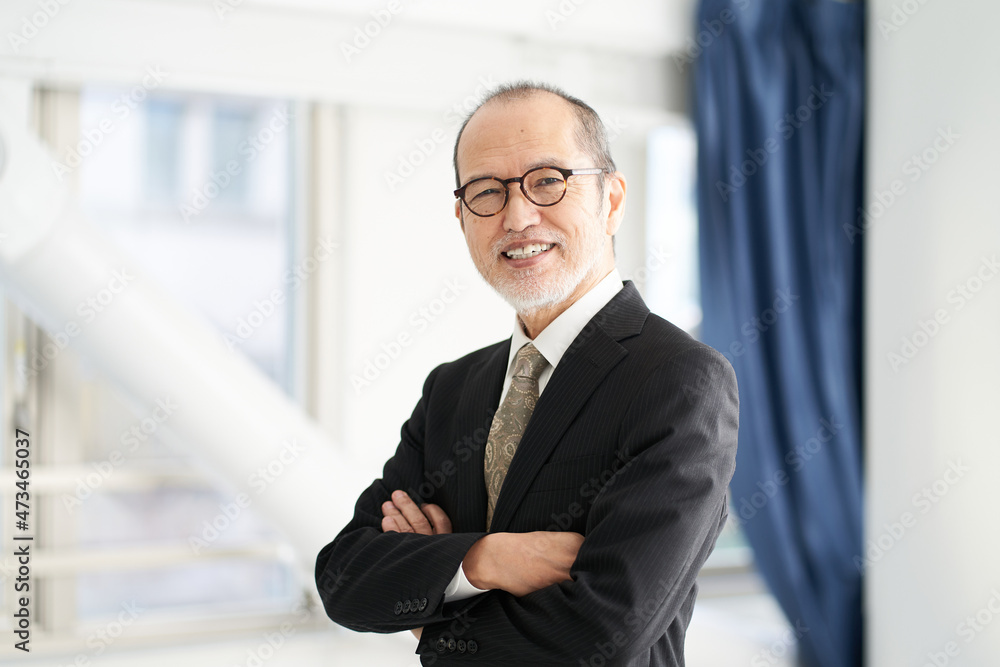 腕組みをする建設会社の管理職の男性 腕組みをする建設会社の管理職の男性