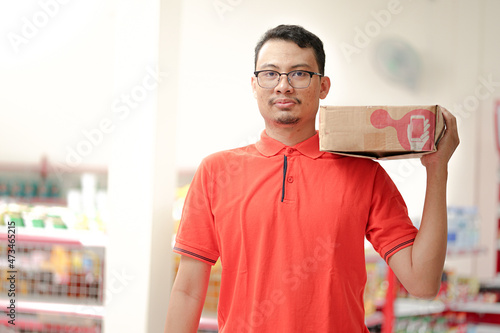 an employee of a supermarket wear uniform lifting inventory items