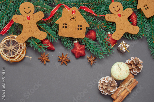 Winter background with Christmas tree branches, cones, Christmas toys and Christmas cookies, with black space for replicas