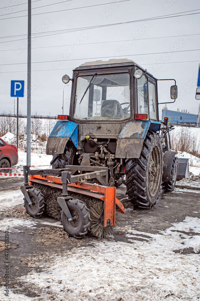 Tractor snow cleaner in the parking lot on a cold winter day Tractor snow cleaner in the parking lot on a cold winter day