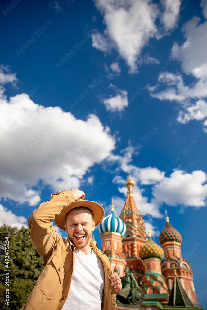 Happy Young man traveler in brown hat taking selfie on Kremlin red square in Moscow. Concept travel to Russia