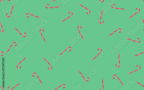 Seamless pattern of striped candy canes on a green background.