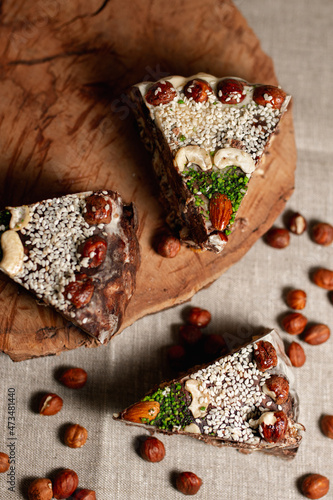 Top view of slices of sweet chocolate halva cake with hazelnuts and sesame seeds served on table in kitchen 