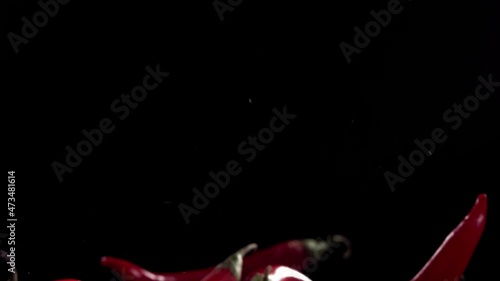 Super Slow Motion Shot of Flying Red Chilli Peppers in the Air photo