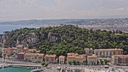 Nice France Aerial v11 cinematic drone flyover castle hill across lympia waterfront harbor at quartier du port toward old city capturing dense historical townscape and seaside promenade - July 2021 photo