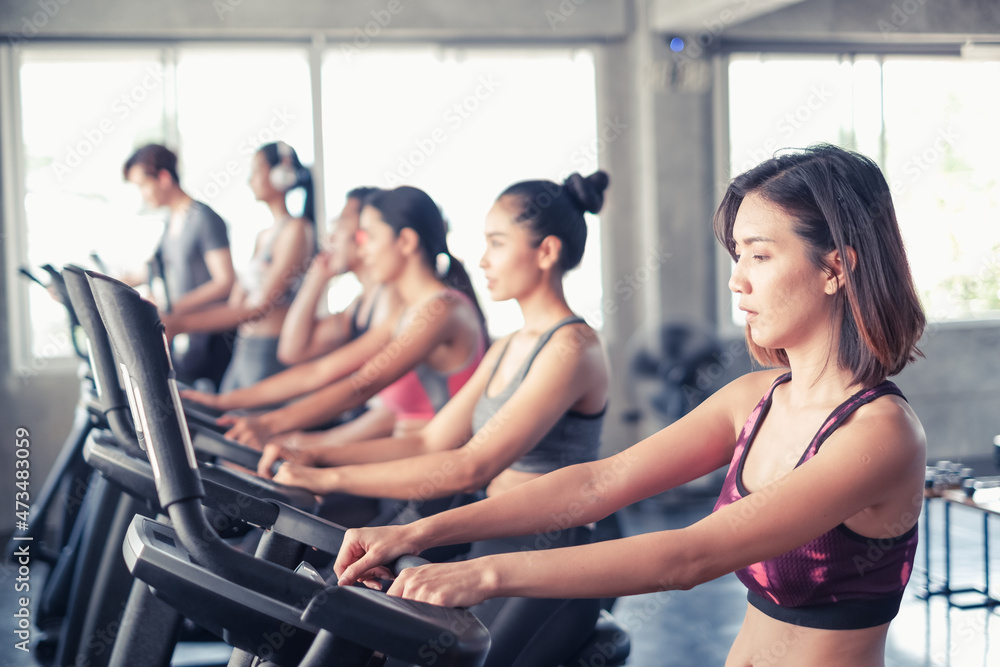 group friends working out on exercise bike and wearing sportswear in fitness or gym center, strength sporty and weight loss concept group friends working out on exercise bike and wearing sportswear in fitness or gym center, strength sporty and weight loss concept