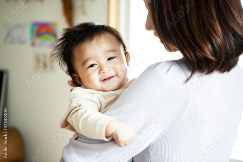 母親に抱き上げられて笑顔の赤ちゃん photo