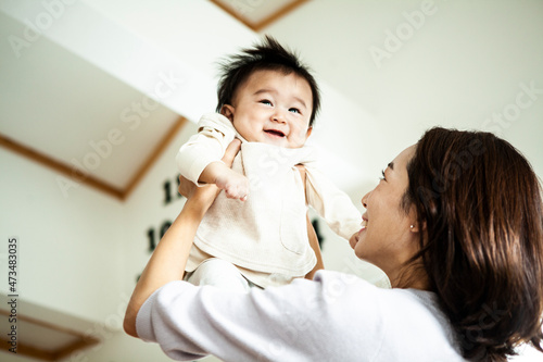 母親に抱き上げられて笑顔の赤ちゃん