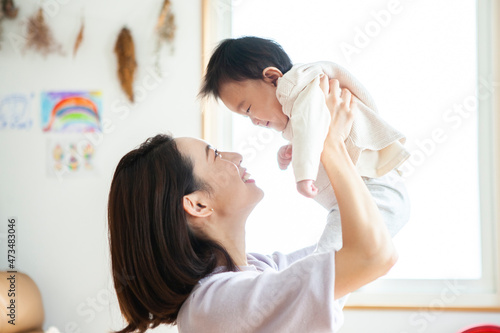 母親に抱き上げられて笑顔の赤ちゃん photo