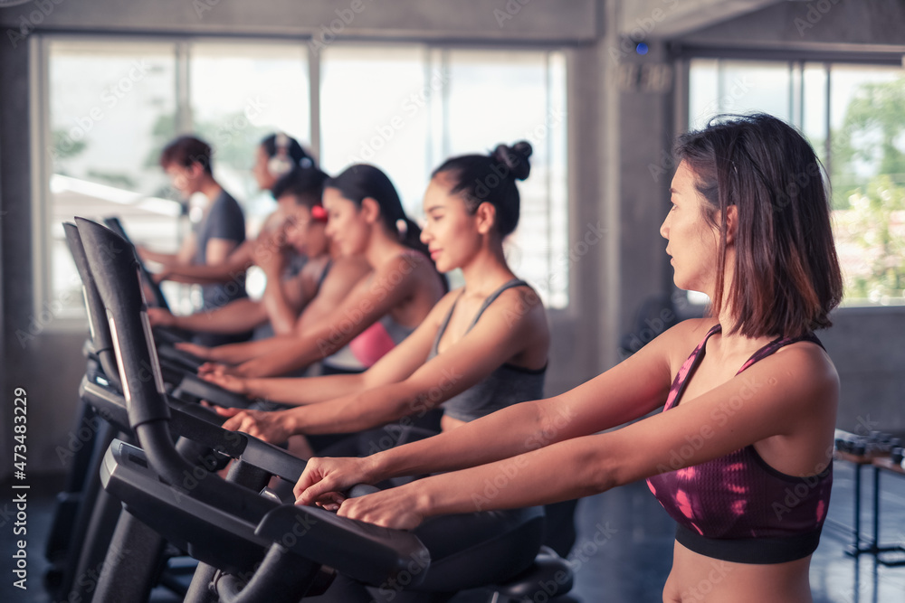 group friends working out on exercise bike and wearing sportswear in fitness or gym center, strength sporty and weight loss concept group friends working out on exercise bike and wearing sportswear in fitness or gym center, strength sporty and weight loss concept