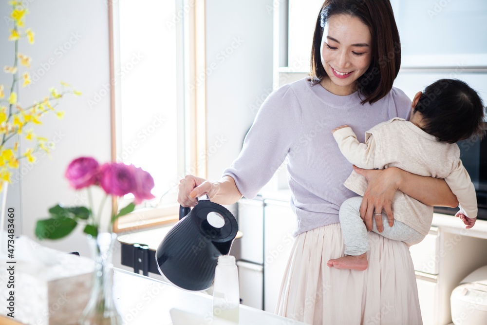 赤ちゃんのためにミルクを準備する女性 赤ちゃんのためにミルクを準備する女性