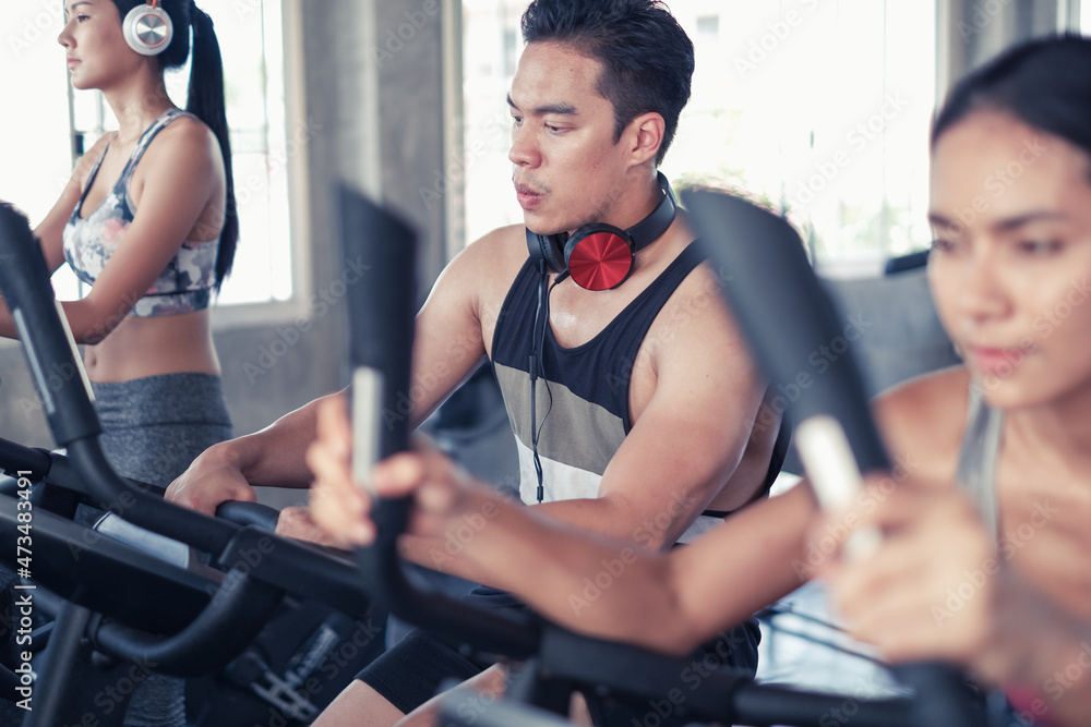group friends working out on exercise bike and wearing sportswear in fitness or gym center, strength sporty and weight loss concept group friends working out on exercise bike and wearing sportswear in fitness or gym center, strength sporty and weight loss concept