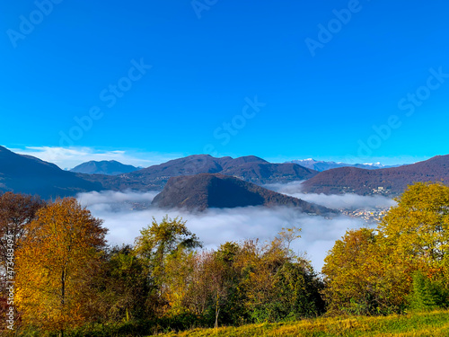 Mountain Range on the Border to Italy on Lake Lugano with Cloudscape and Sunlight on a Clear Sky in Caslano, Ticino in Switzerland. photo