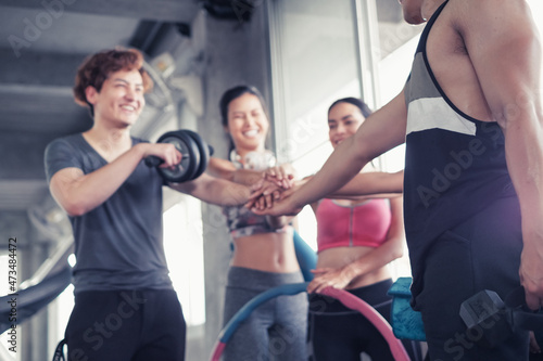 Smiling group of asia friends, happy young women and men relax together after a workout at gym center, Strength sporty and weight loss concept