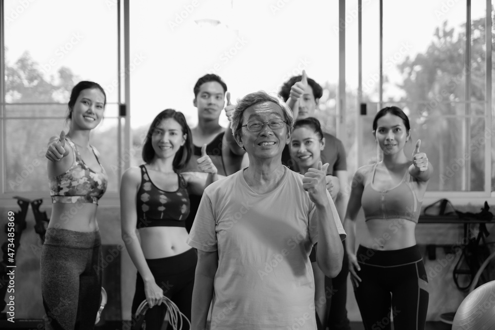 Fototapeta premium Senior man and young group people, Friends different ages in gym working out