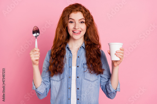 Photo of pretty hungry young woman wear denim shirt showing tongue ready to eat ready quick soup isolated pink color background