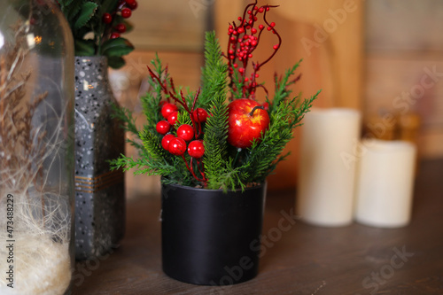 Festive decoration of the New Year's table, serving dishes for New Year's dinner, cones, tangerines, fir branches, garlands, candles and glasses, bokeh on the background. The concept of Christmas