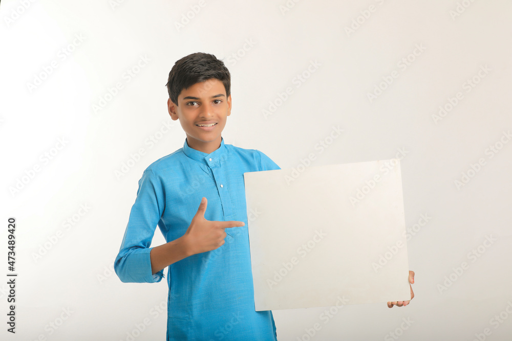 Indian little child in traditional wear and showing white board.