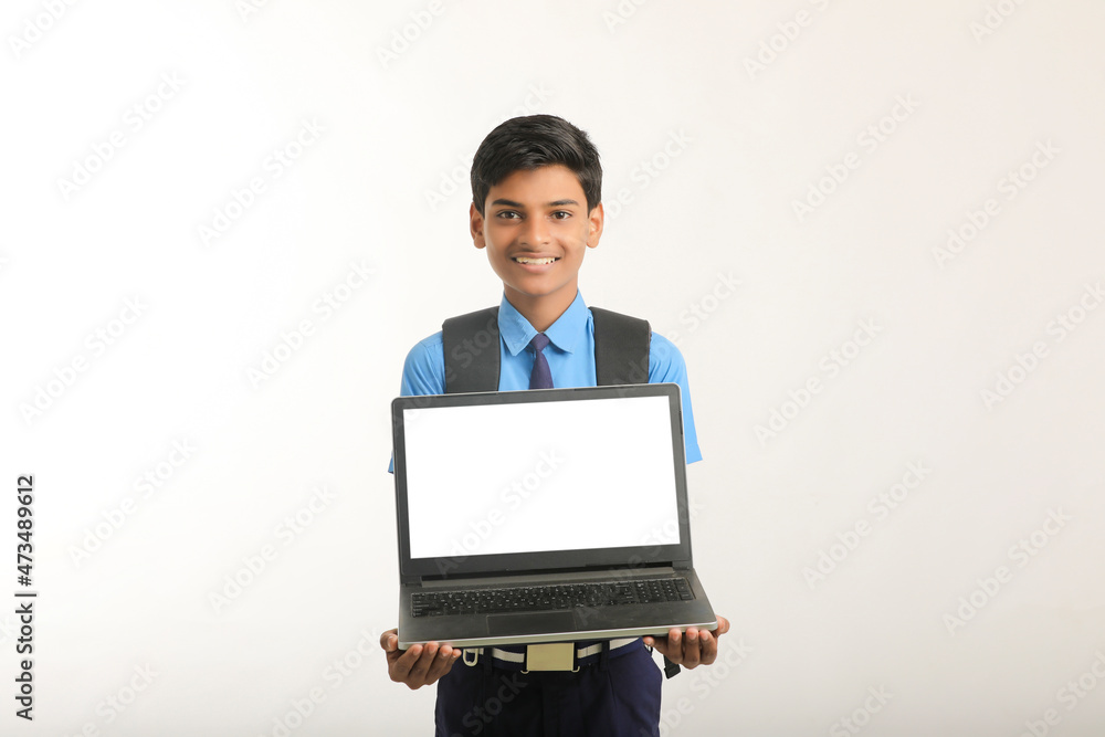 Indian school boy showing laptop screen on white background. Indian school boy showing laptop screen on white background.