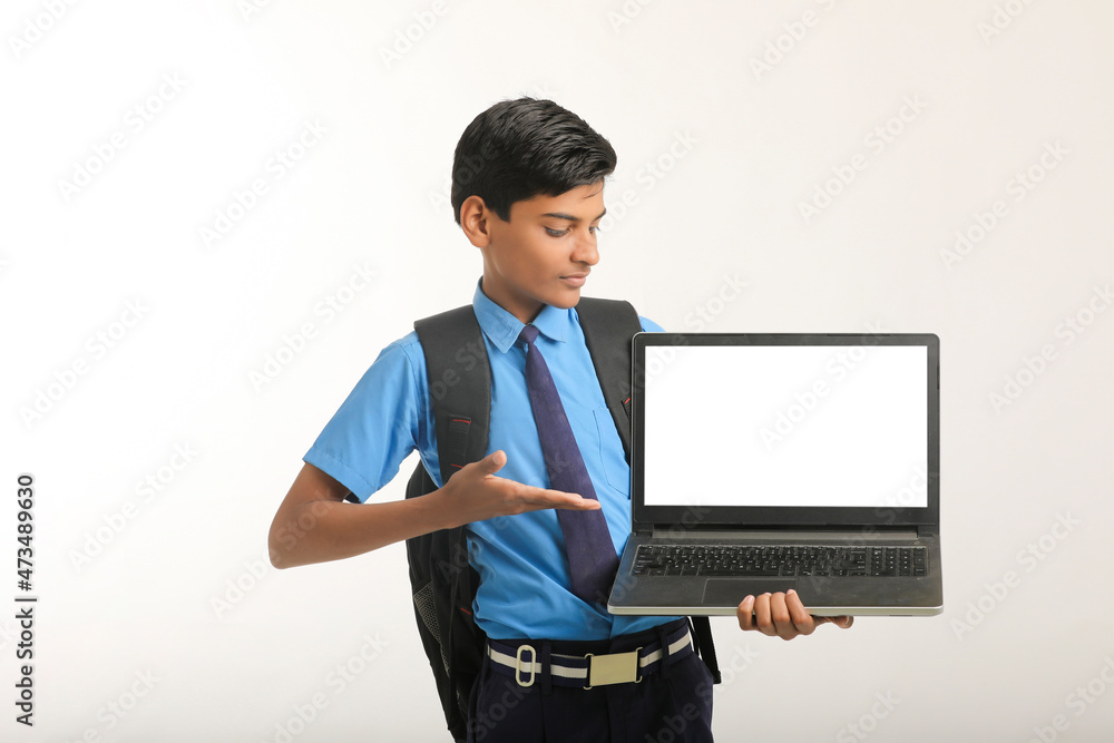 Indian school boy showing laptop screen on white background. Indian school boy showing laptop screen on white background.