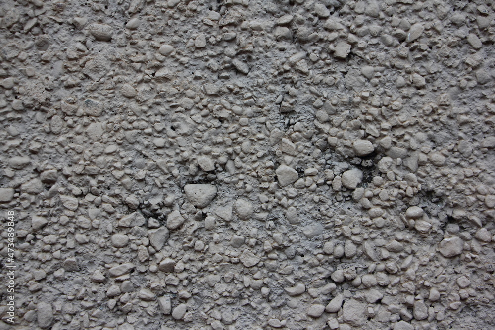 Rough gray dry concrete surface interspersed with crushed stone close up industrial background texture Rough gray dry concrete surface interspersed with crushed stone close up industrial background texture