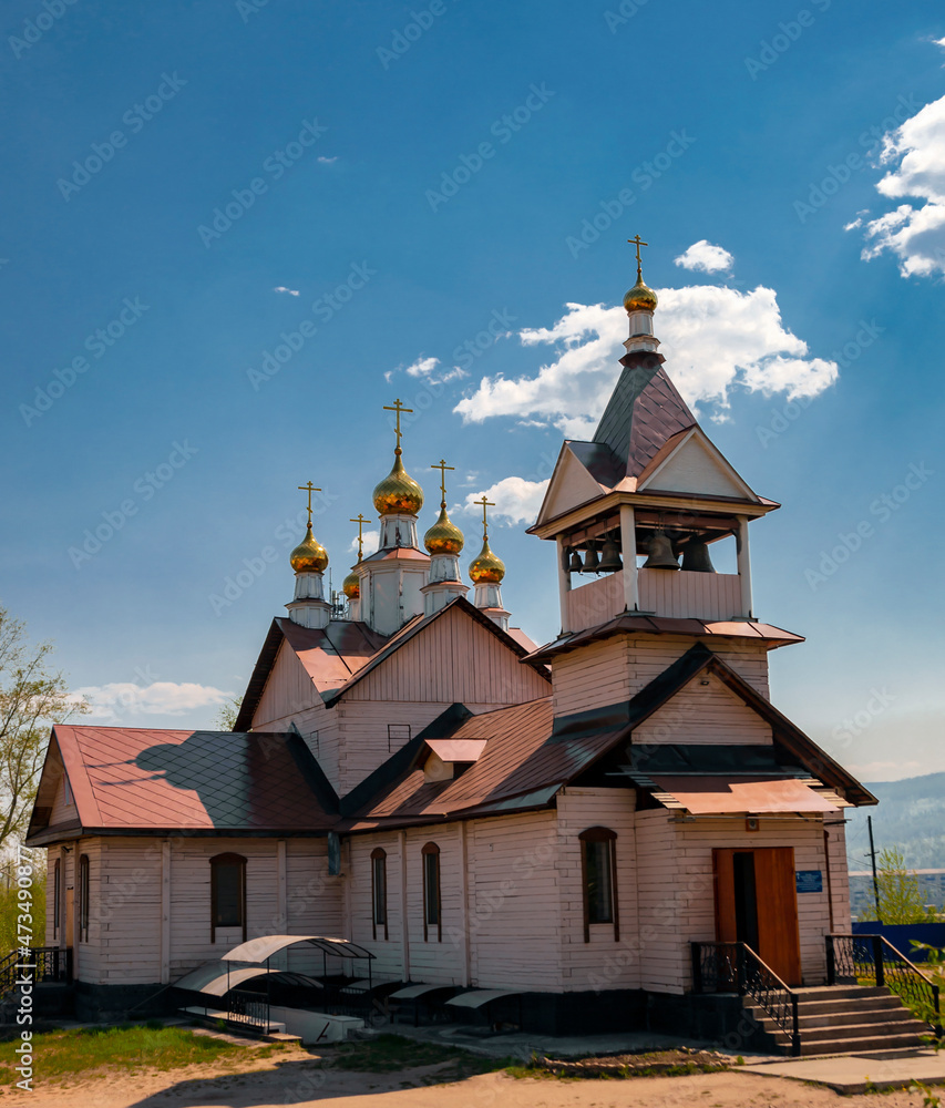 View of the wooden church building in honor of the image of the Savior Not Made with Hands in Ust-Kut in June. View of the wooden church building in honor of the image of the Savior Not Made with Hands in Ust-Kut in June.