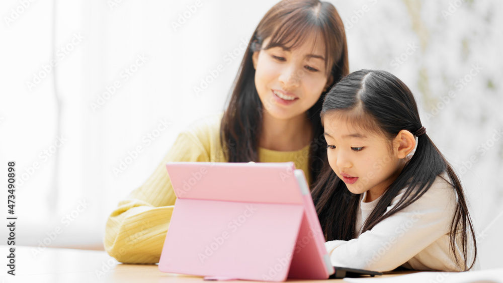 タブレットパソコンで勉強する女の子とその母親 タブレットパソコンで勉強する女の子とその母親