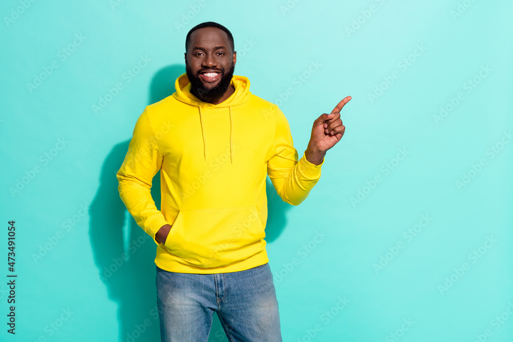 Photo of guy positive promoter point hand empty space select ad promo isolated over cyan color background Photo of guy positive promoter point hand empty space select ad promo isolated over cyan color background