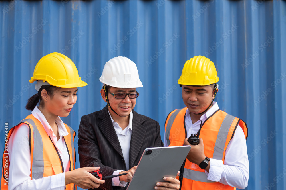 Group of logistic engineering and supervisor, using wireless tablet to see delivery information and orders while planning for container shipment. Logistic workers business. Group of logistic engineering and supervisor, using wireless tablet to see delivery information and orders while planning for container shipment. Logistic workers business.