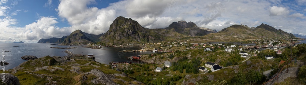 panorama of sunny day at reine Lofoten islands norway with blue sky and tiny clouds, fishermen village with huge mountains in a fjord