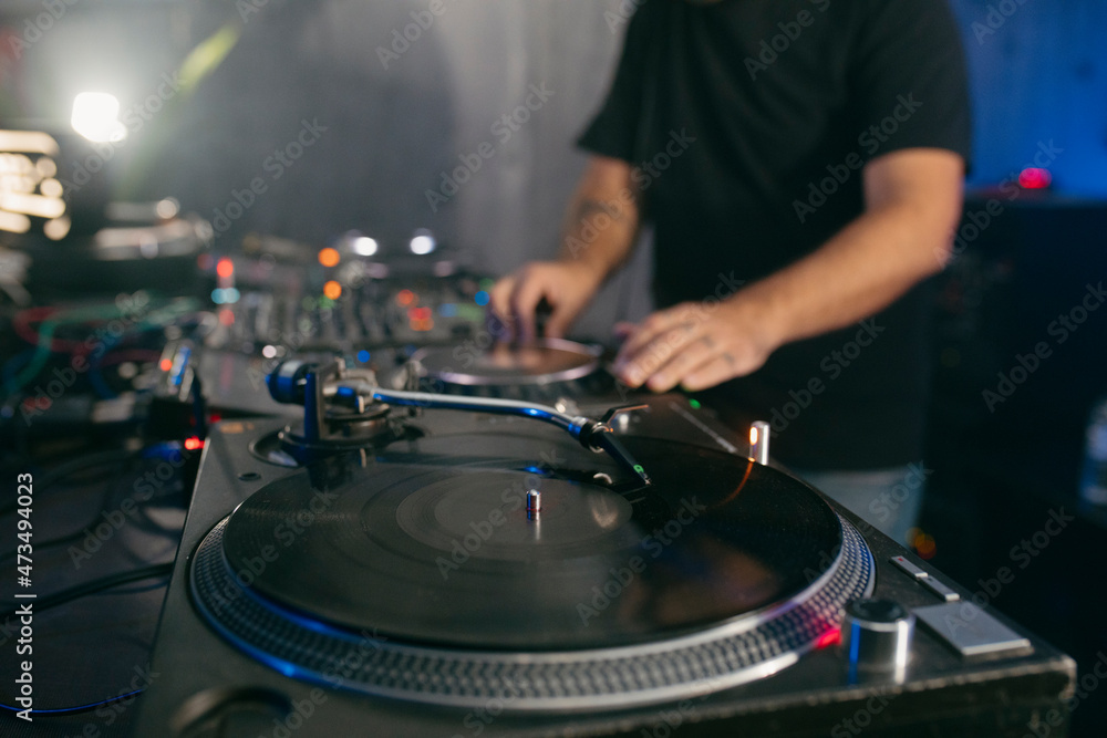 View of a deejay using vinyl turntables during a musi set View of a deejay using vinyl turntables during a musi set