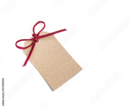 Brown recycled paper cardboard label with red shiny cord isolated on white