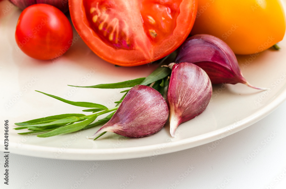 fresh herbs, tomatoes and garlic on a white plate fresh herbs, tomatoes and garlic on a white plate