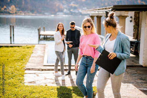 Female entrepreneur discussing with customer by lake photo