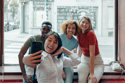 group of multiethnic expats students taking selfies with mobile phone photo