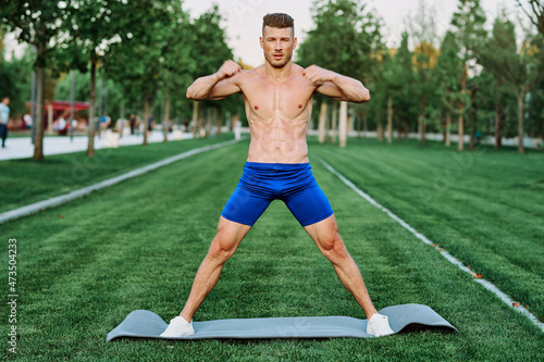 sporty muscular man goes in for sports in the park workout motivation