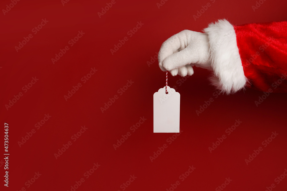 custom made wallpaper toronto digitalsanta claus hand holding white blank tag label on red background with copy space